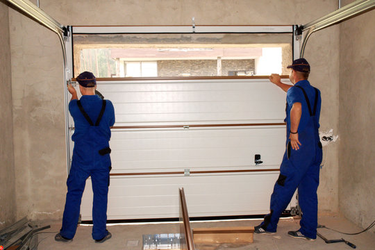 Technician repairing a residential garage door in San Diego CA