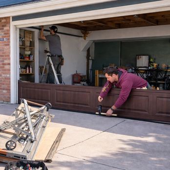 professional garage door repair technician fixing residential garage door