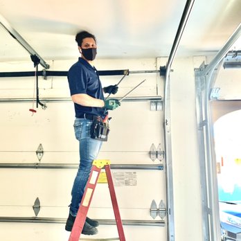 professional garage door repair technician fixing residential garage door